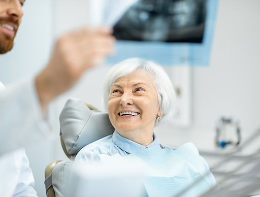 A dentist reviewing a dental X-ray with a patient