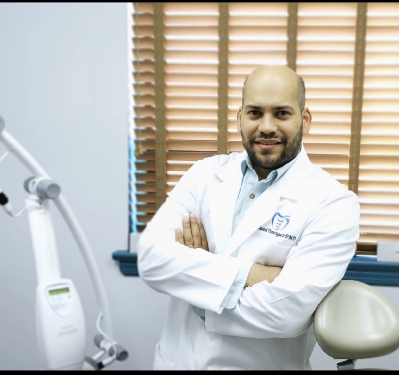 Dr. Edward Dominguez wearing his white coat in the dental office